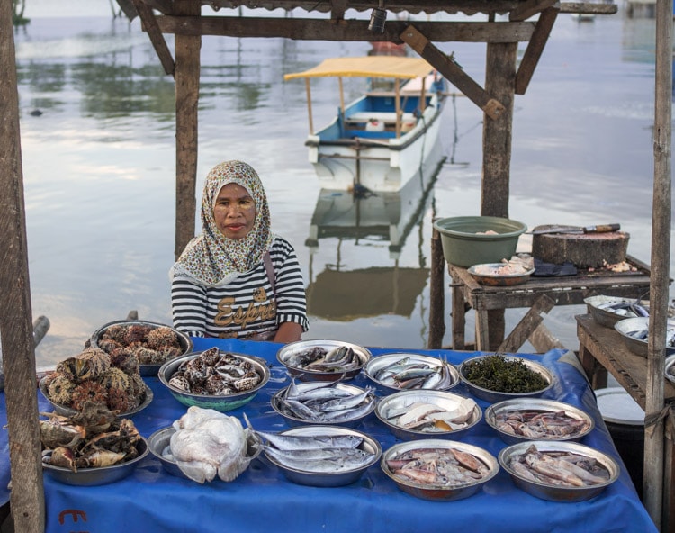 Woman selling fish in local market, Maumere, Indonesia