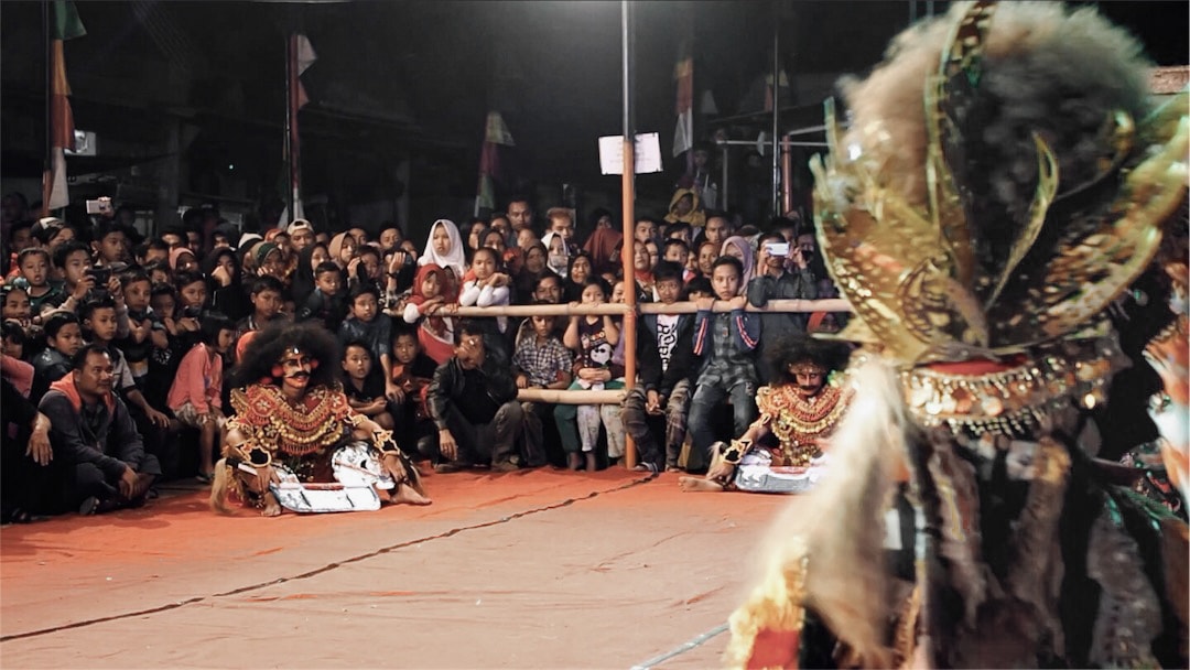 Javanese people gathered around a stage to watch a Kuda Lumping (horse dance) performance.