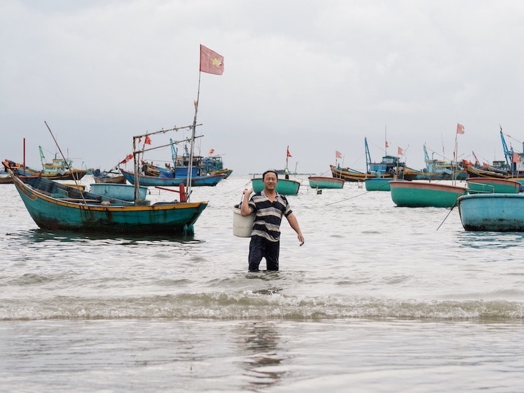 Fisherman wading in the waters, Mui Ne, Vietnam
